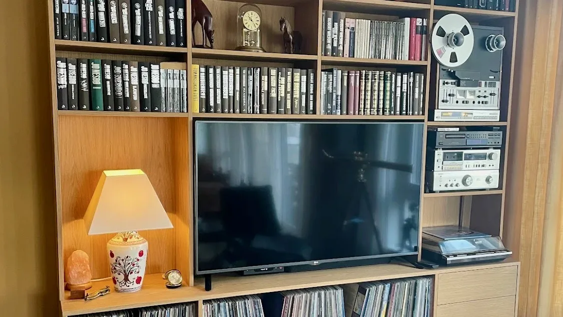 Mediahylle i eik i bruk, med platesamling, båndspiller, stereo og TV.