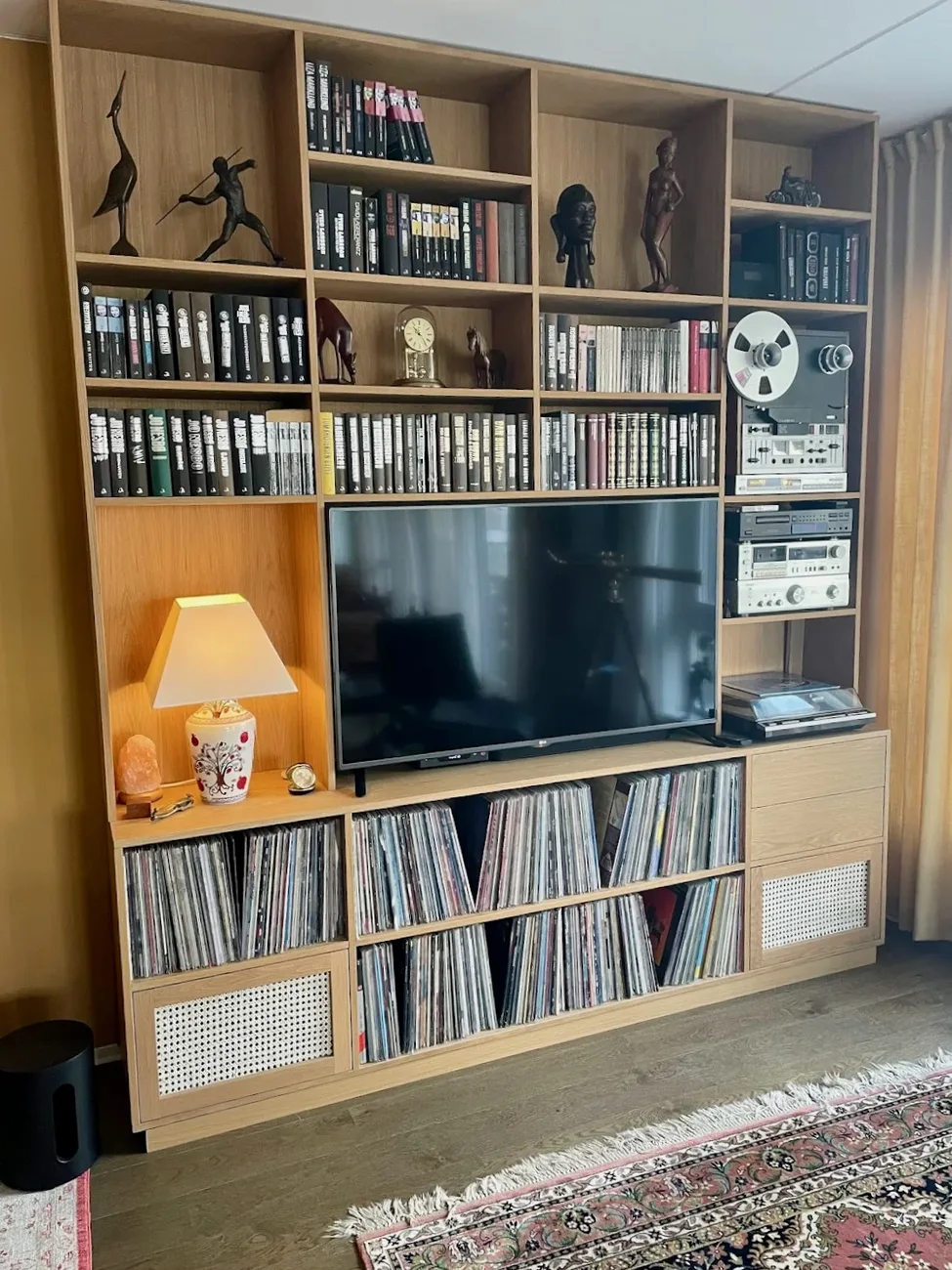 Mediahylla ferdig stylet i stua, med platesamling, stereo, TV og pyntegjenstander.